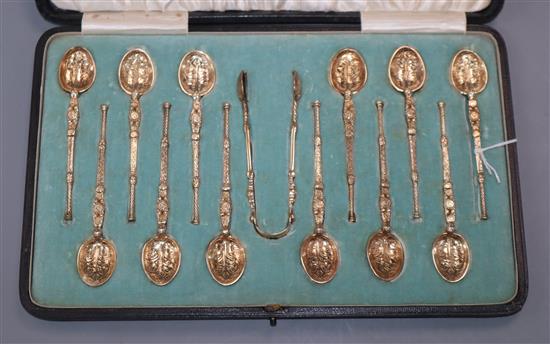 A cased set of 12 silver gilt coffee spoons, Elkington & Co, 1906/7, with similar tongs, Edward Barnard & Sons, London, 1901.